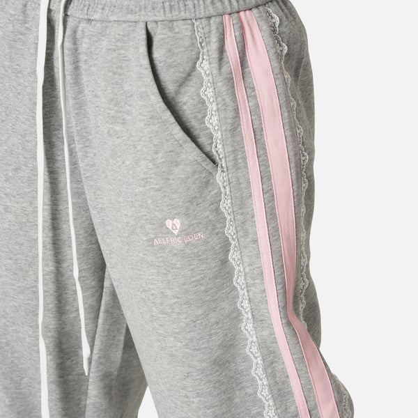 Pantalón baggy con bandas rosas y lazos laterales